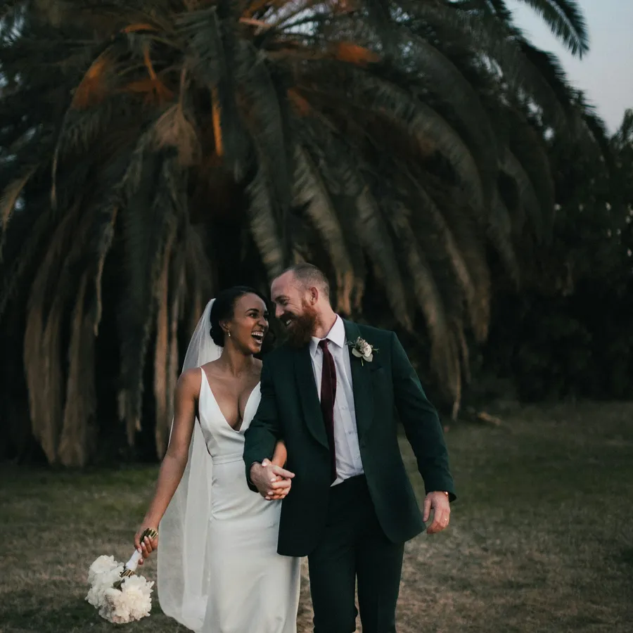 Couple walking beneath palm trees