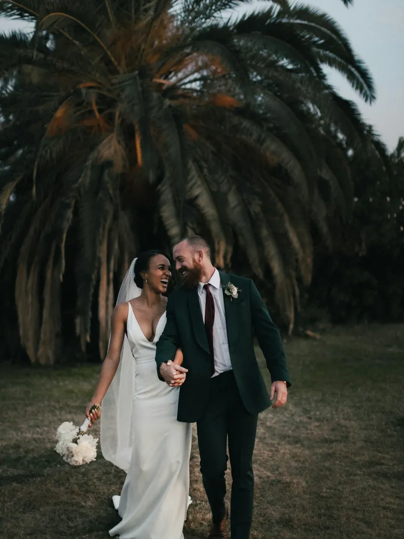 Couple walking beneath palm trees