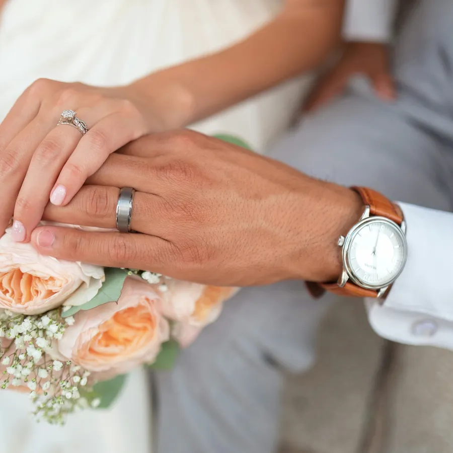 Hands with wedding rings and bouquet